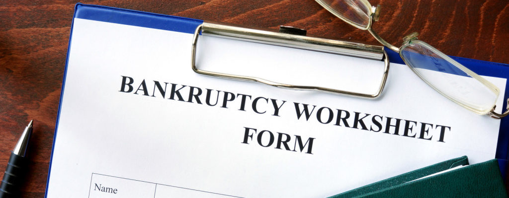 Bankruptcy worksheet form on a wooden table. | Rulon T Burton